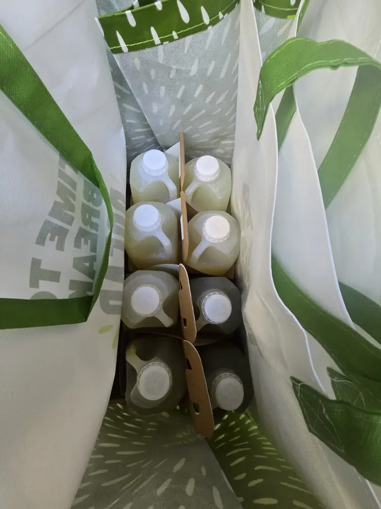 Bottled catering drinks held upright in cardboard carriers inside delivery bags